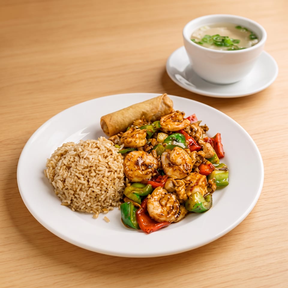 Shrimp stir-fry with bell peppers, brown rice, an egg roll, and a cup of soup.